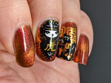A lovely red, pink, and gold multichrome magnetic nail polish paired with tiger paper cut stamping images for a Year of the Tiger zodiac mani.