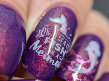 A purple shimmery mermaid nail art that says "In a sea of fish, be a mermaid" with mermaid, mermaid tail, and fish stamping images.