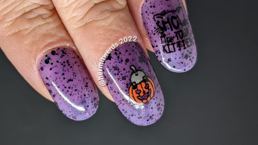 A Halloween cat nail art with sweet black kitties climbing into things on a purple jelly polish filled with black and holographic glitter.
