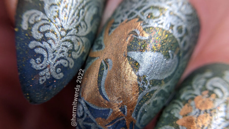 Fox nail art of an art deco fox on swirling patterns, fox prints, and a woodland fox patern on a dark blue and green thermal.