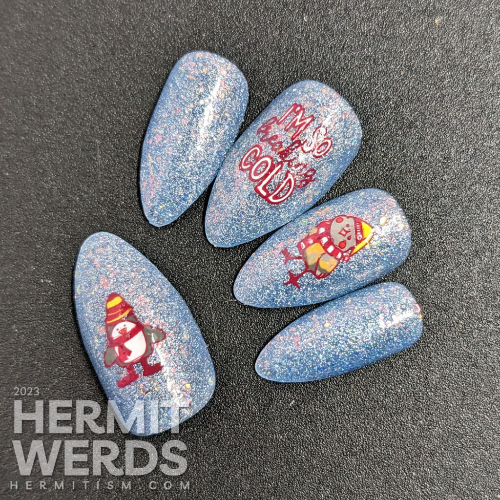 Cute little winter bird nail art with stamping decals of birds in hats and scarves on an extra glitzy blue nail polish