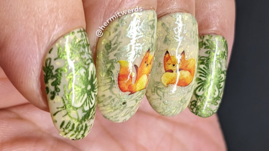 A sweet fox nail art using watercolor-esque fox water decals on top of a pale yellow crelly base with metallic floral prints stamped on top.