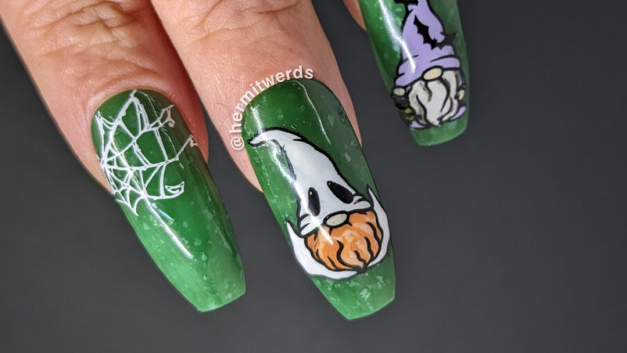 Spooky gnome nail art with spider webs and three gnomes dressed as a bat-loving witch, a ghost, and a cobweb covered spider lover.