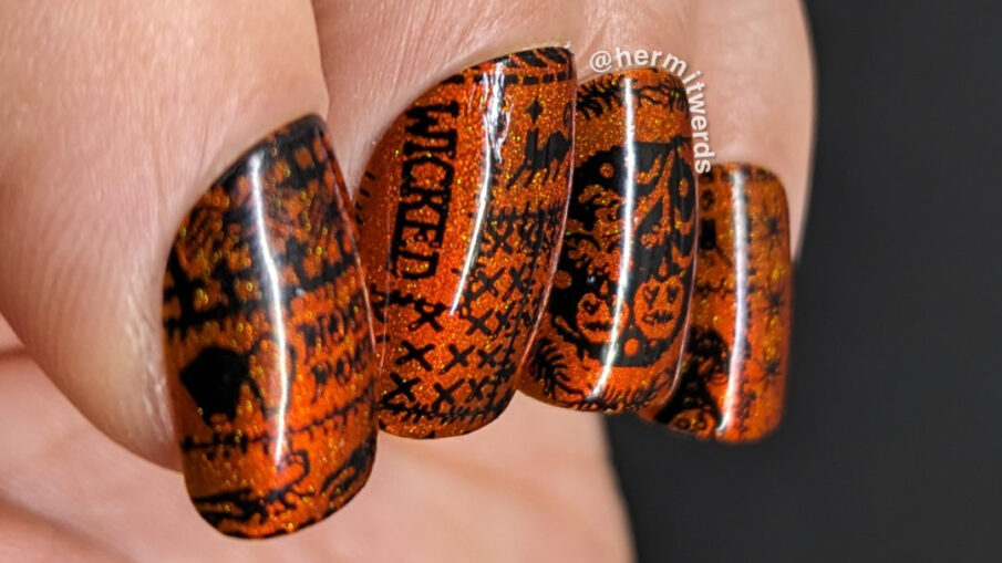 A simple orange magnetic Halloween quilt nail art with cozy quilt patterns of everything from pumpkins to black cats to spiders in black.