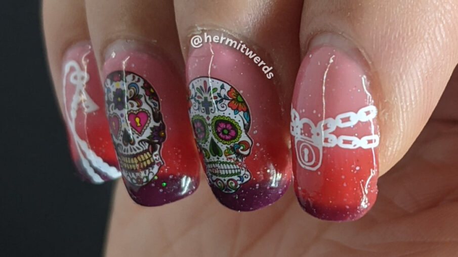 Day of the Dead (Día de los Muertos) water decals of ornate sugar skulls on a thermal holographic polish that moves from pink to purple.