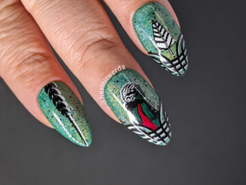 An art deco Christmas nail art w/a green magnetic holo background and nail stamped art deco lady, Christmas tree, and framing flourishes.