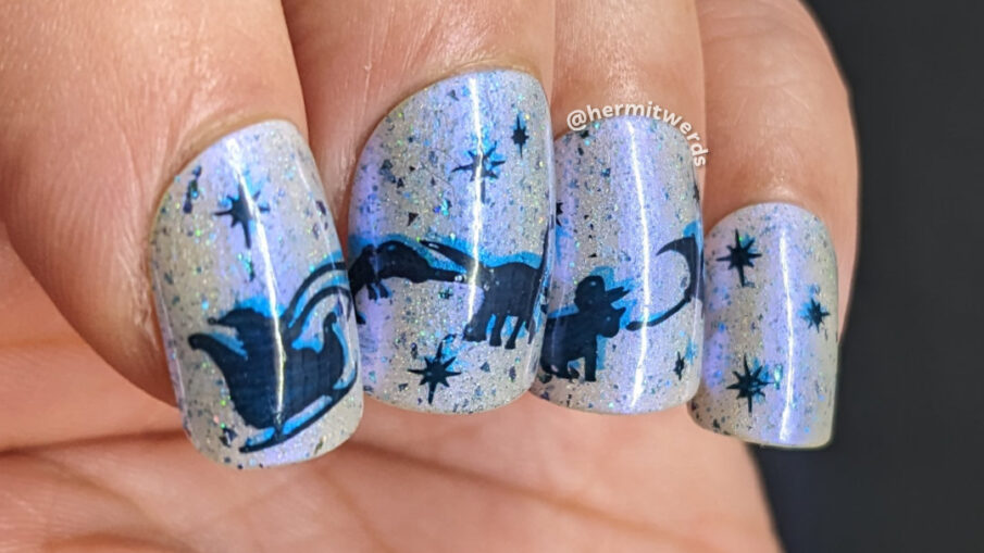 Christmas nail art of Santa's sleigh with dinosaurs (t-rex, brontosaurus, triceratops, and pterodactyl) flying across a glow in the dark sky.