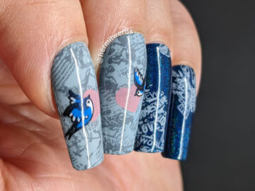 Love bird nail art with tons of newsprint, hearts, "love" and two sweet blue birds in flight on a grey/blue or holographic blue background.